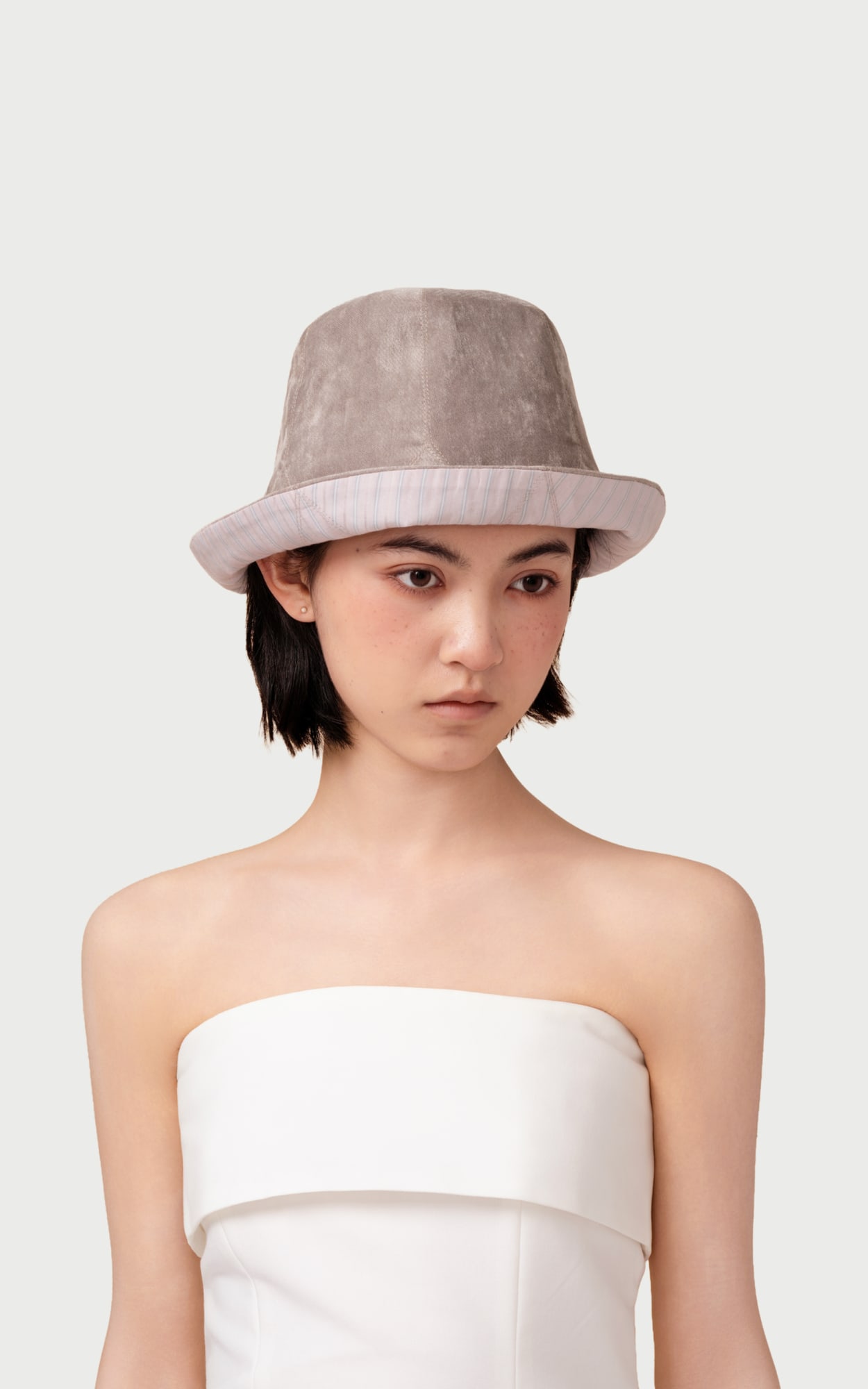 Mist Grey Reversible Bucket Hat worn by a model